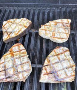 Swordfish steaks with butter and herbs on grill