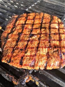 Flank steak on grill with sear marks