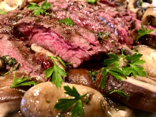 Sliced Steak and Mushrooms with Fresh Parsley Garnish