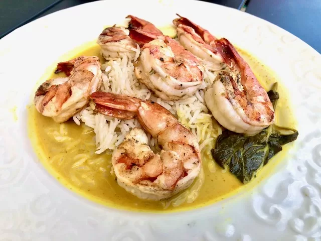 Thai Curry with Grilled Shrimp over rice on a plate by Sear Marks