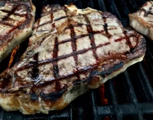 T Bone Steak with Sear Marks sitting on grill grates