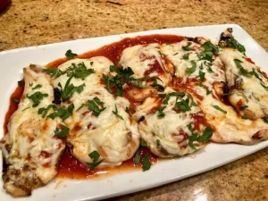 Grilled Chicken Parmesan sitting on a plate.