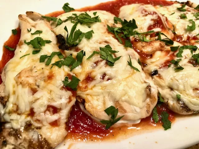 Grilled Chicken Parmesan with Fresh Parsley on a plate