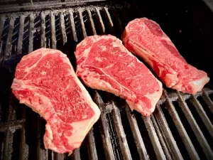 Steaks on grill grates by Sear Marks