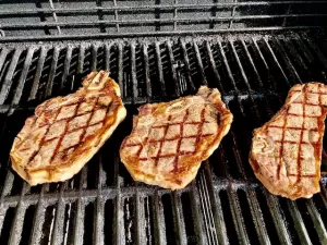 Strip Steaks with Grill Marks sitting on the grill.