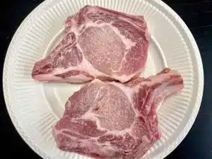 Two Pork Chops sitting on a white plate