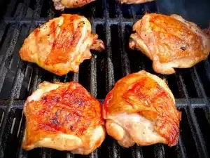 juicy grilled chicken thighs on grill grates