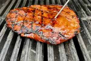 Flank Steak with meat thermometer on grill grates