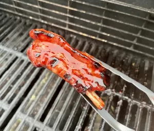 Grilling tongs holding spare rib