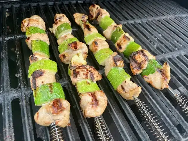 Marinated Soy and Ginger Chicken Skewers sitting on grill grates